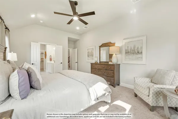 a spacious bedroom with a bed a couch and a chandelier