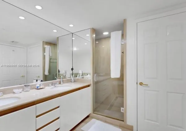 a bathroom with a double vanity sink mirror and shower