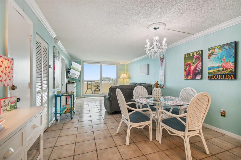5915 Sea Ranch Drive, Unit 308 Hudson, FL 34667 - Photo 18 of 64 a dining room with furniture a rug a flat screen tv and a chandelier