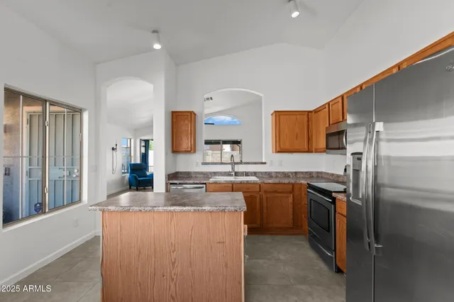 a kitchen with stainless steel appliances granite countertop a sink stove and refrigerator