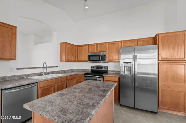 a kitchen with stainless steel appliances granite countertop a sink stove and refrigerator
