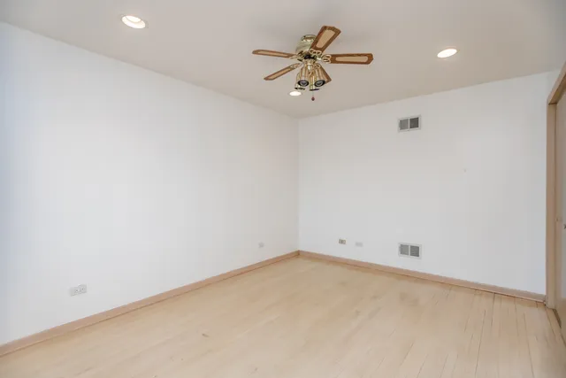 an empty room with a ceiling fan and a window