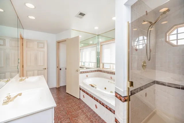a bathroom with a tub sink and mirror