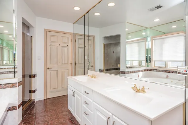 a bathroom with a tub sink and mirror