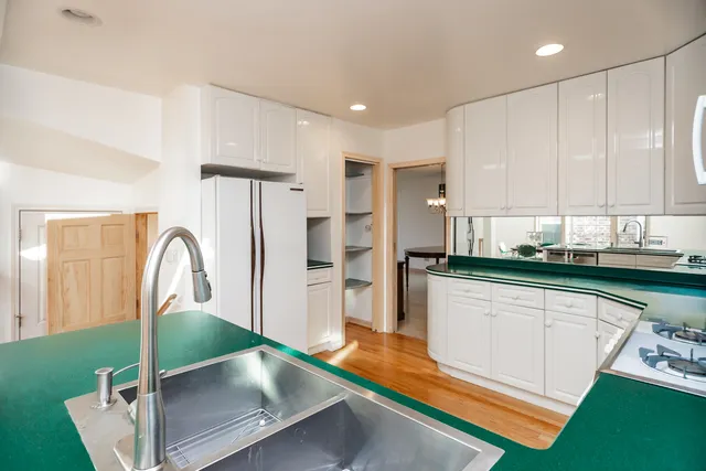 a kitchen with stainless steel appliances granite countertop a refrigerator a sink and a stove