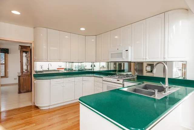 a kitchen with stainless steel appliances granite countertop a stove top oven a sink dishwasher and cabinets with wooden floor