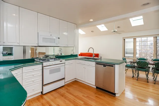 a kitchen with granite countertop white cabinets and white appliances