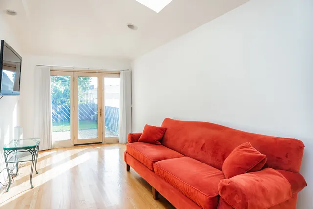 a blue couch sitting in a living room next to a window