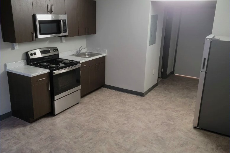 4205 Hatch Boulevard Sheffield, AL 35660 - Photo 5 of 12 a kitchen with stainless steel appliances a stove a microwave a sink and a refrigerator