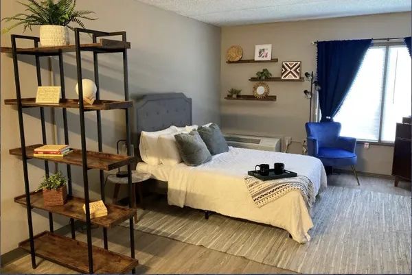 a living room with furniture a refrigerator and kitchen view