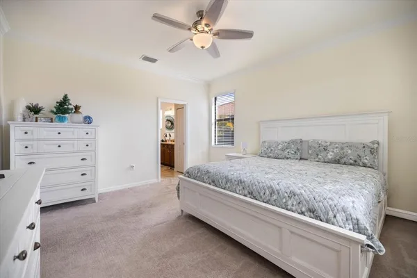 a spacious bedroom with a bed and a ceiling fan