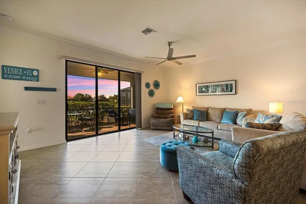a living room with furniture a floor to ceiling window and a flat screen tv