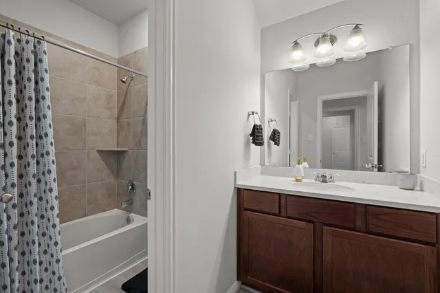 a bathroom with a tub sink and mirror