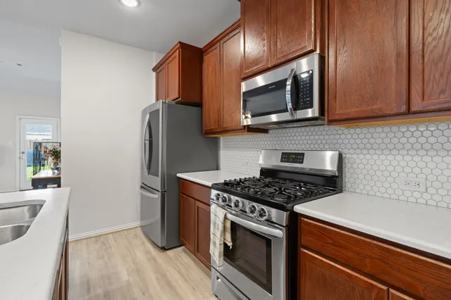 a kitchen with stainless steel appliances granite countertop a stove microwave and refrigerator