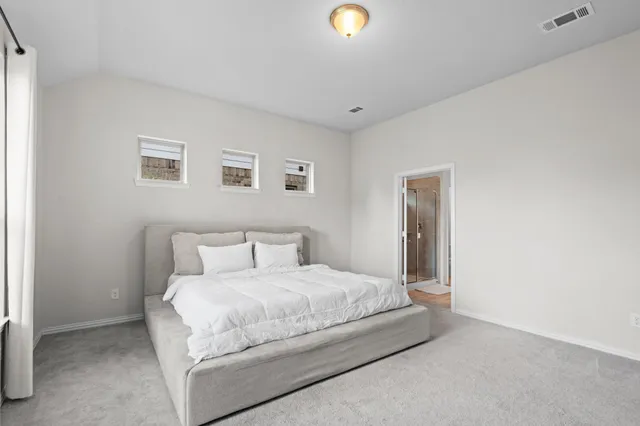 a bedroom with a bed and painting on the wall