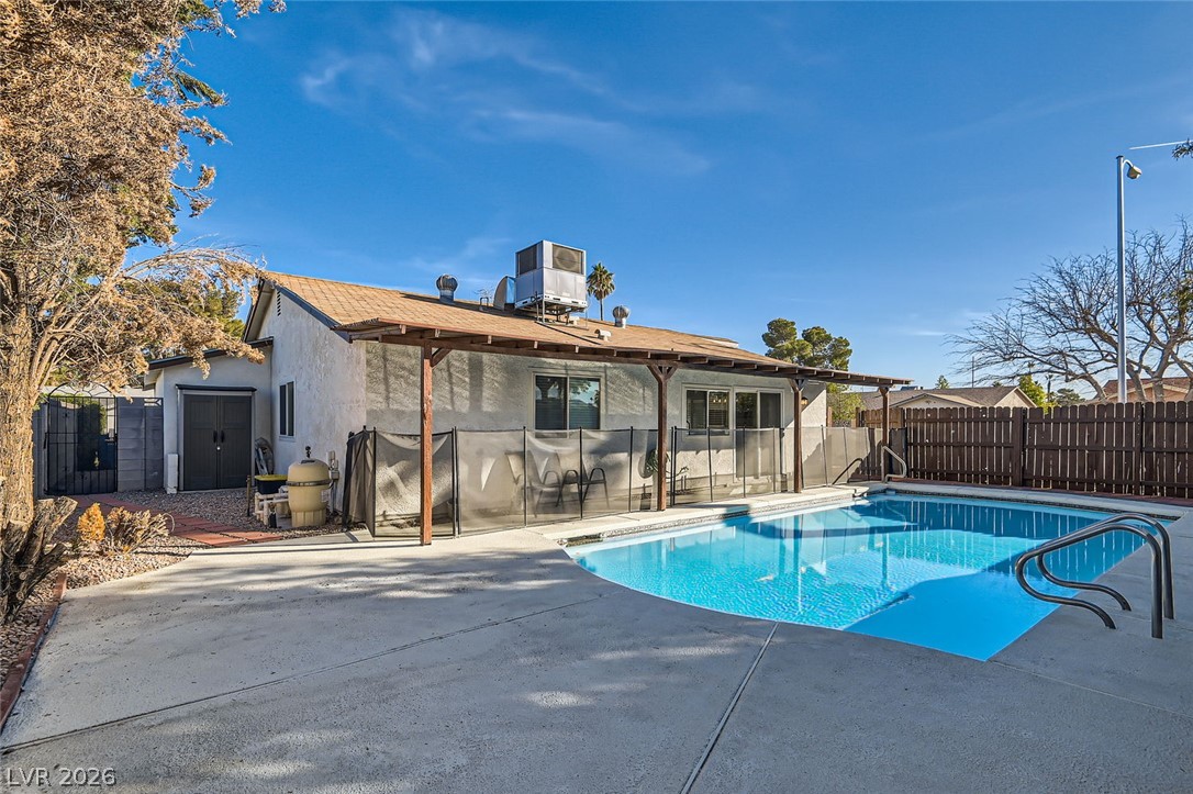 3665 Bronco Road Las Vegas, NV 89103 - Photo 26 of 28 An inviting backyard oasis offers a pristine swimming pool and a shaded patio area, perfect for unwinding.
