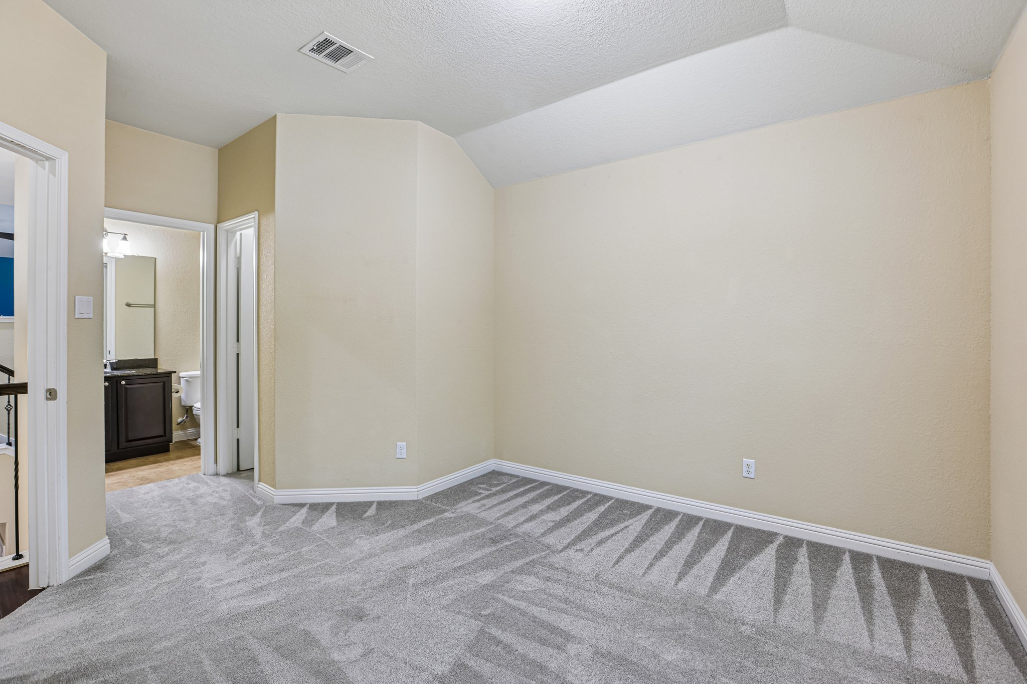 1924 Granite Springs Road Leander, TX 78641 - Photo 25 of 36 Guest Bedroom #2 with connected bathroom. An inviting room features plush carpeting and a high vaulted ceiling, with a nearby bathroom for convenience.