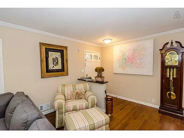a living room with furniture and painting on the wall