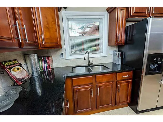 a kitchen with stainless steel appliances granite countertop a refrigerator and a sink