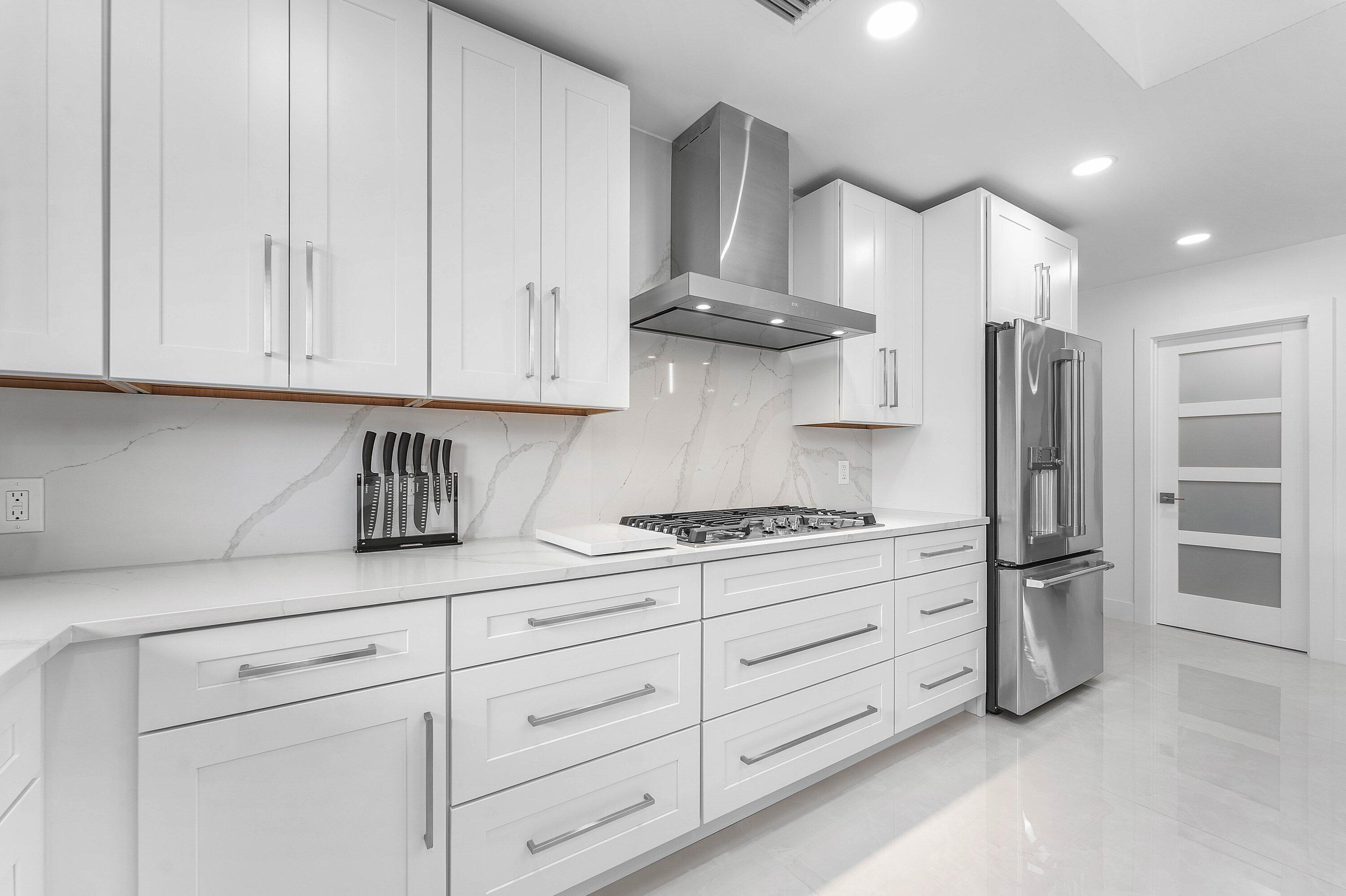 8274 Sawpine Road Delray Beach, FL 33446 - Photo 18 of 63 a kitchen with stainless steel appliances granite countertop a stove a refrigerator and a white cabinets