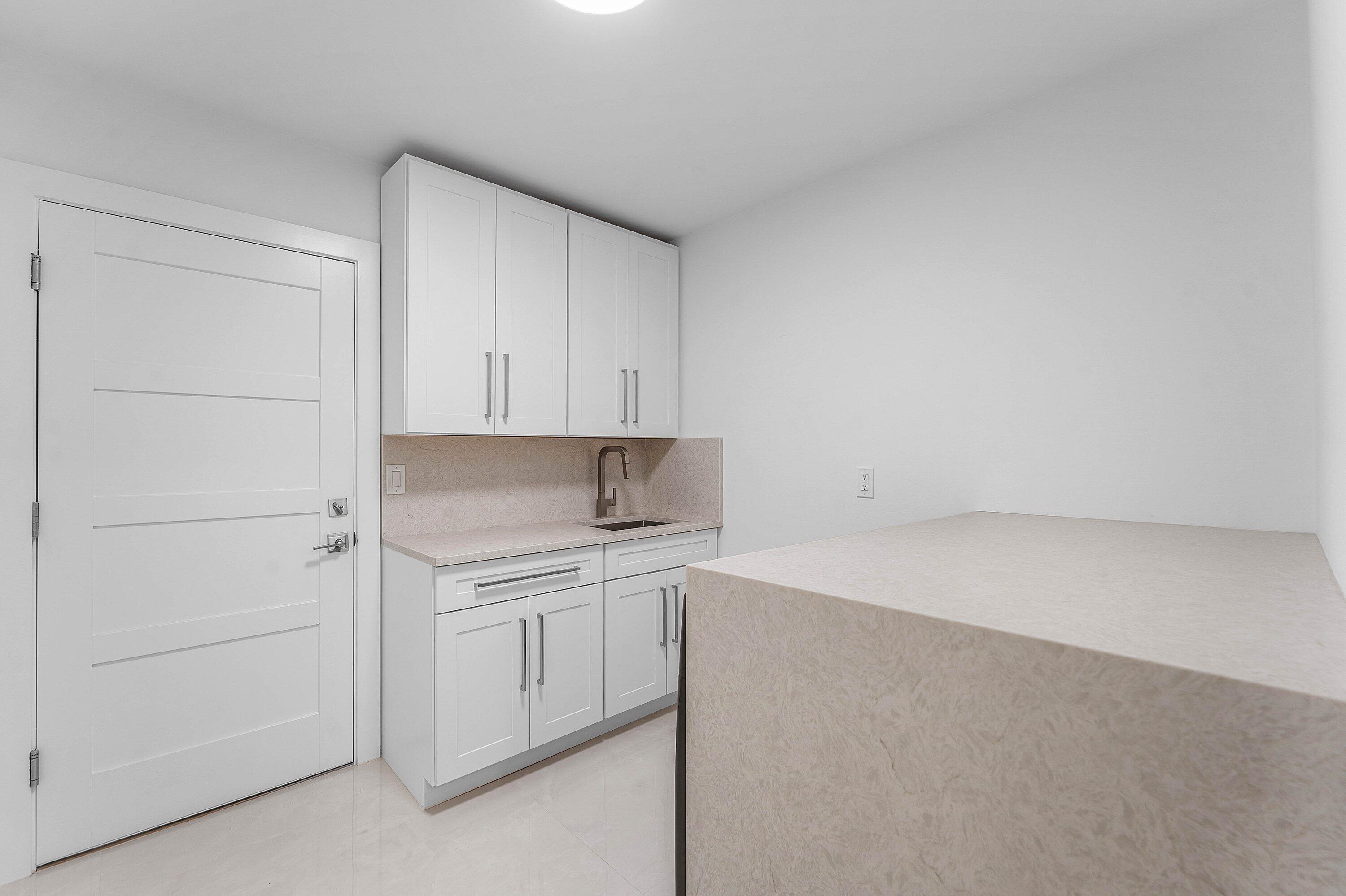 8274 Sawpine Road Delray Beach, FL 33446 - Photo 32 of 63 a view of a kitchen with white cabinets and wooden floor