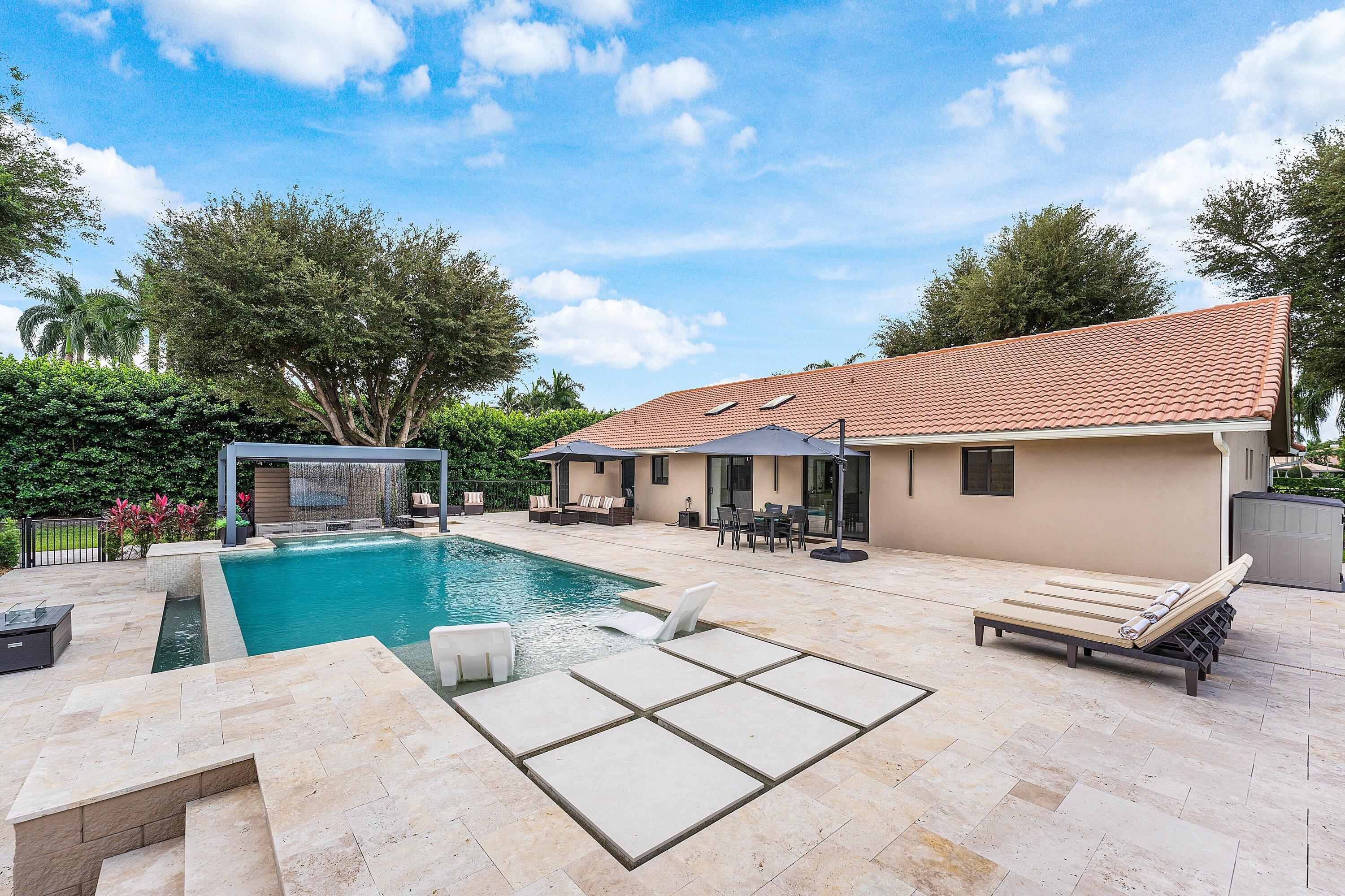 8274 Sawpine Road Delray Beach, FL 33446 - Photo 41 of 63 a view of a patio with a table and chairs under an umbrella