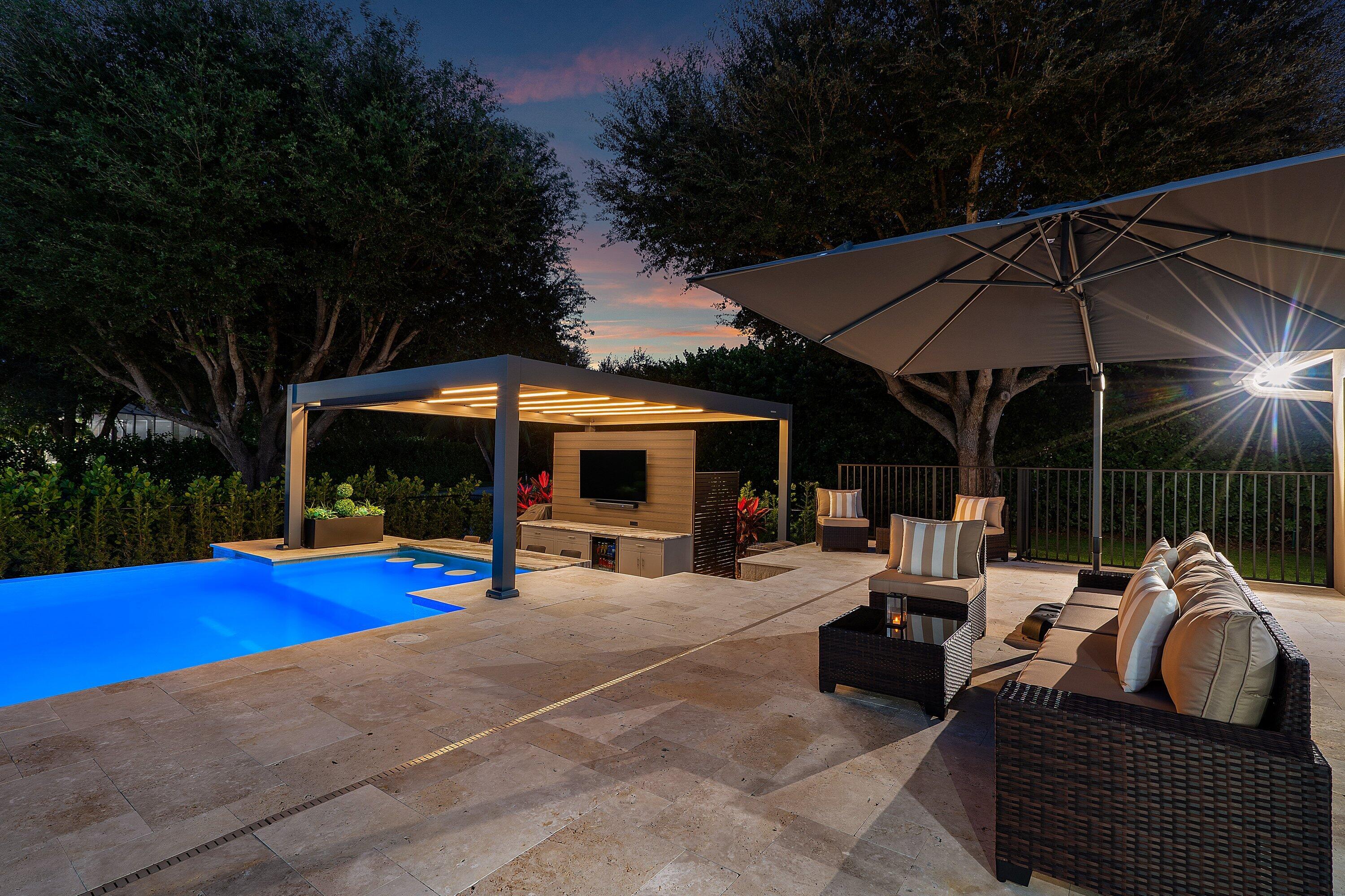 8274 Sawpine Road Delray Beach, FL 33446 - Photo 61 of 63 a view of a patio with table and chairs under an umbrella