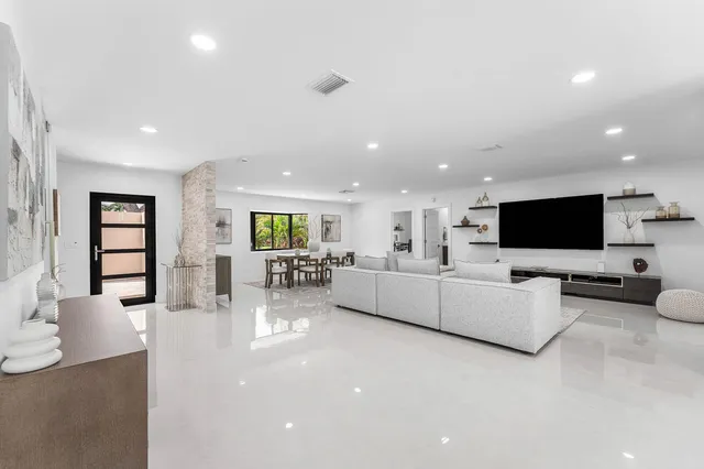 a large kitchen with kitchen island a large counter top space a sink stainless steel appliances and cabinets