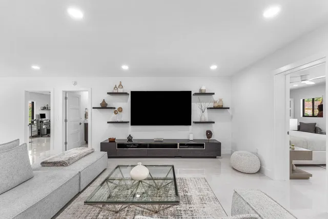 a large white kitchen with a large window and stainless steel appliances