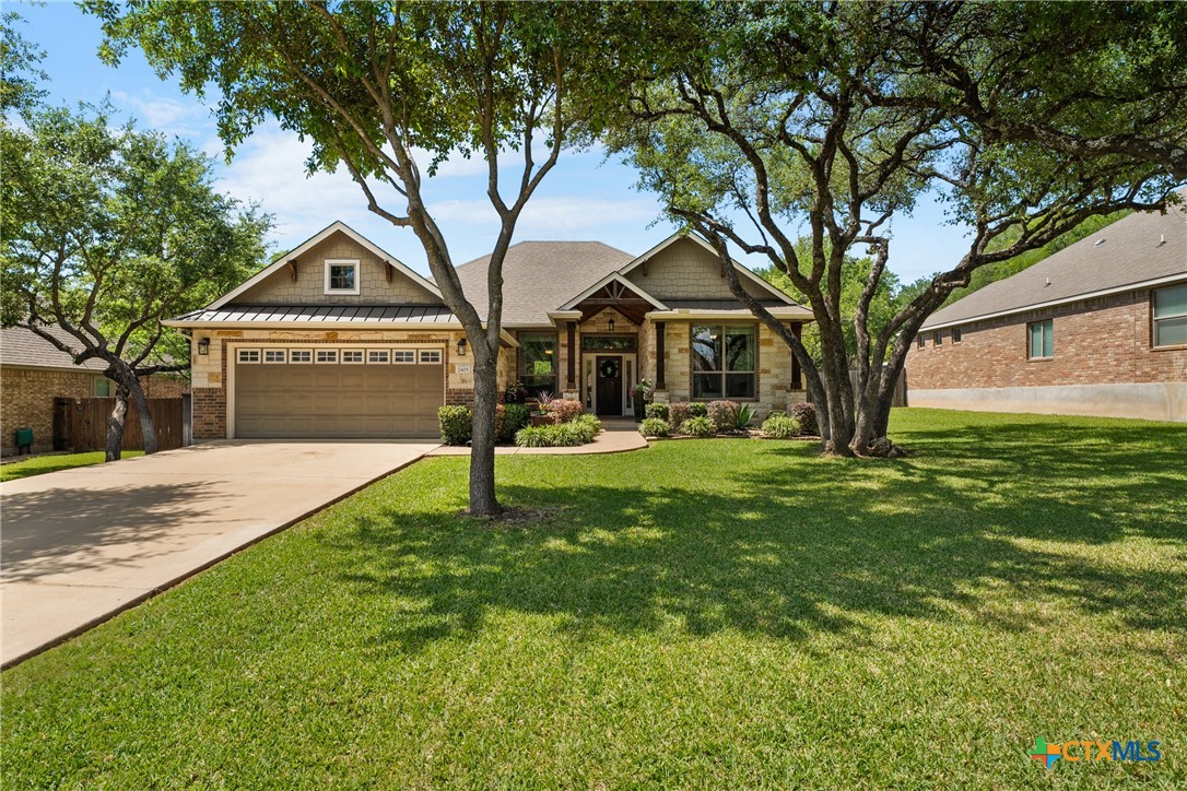 a front view of a house with a yard and tree