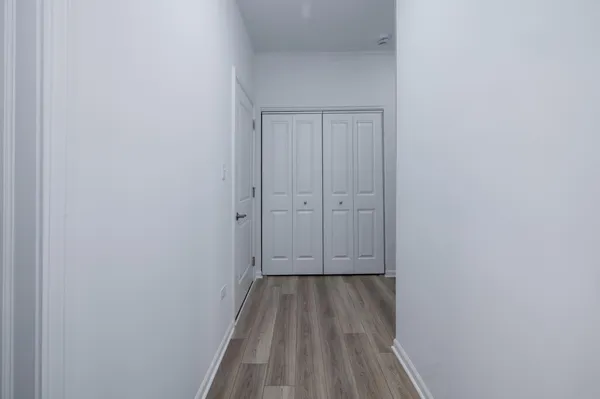 a view of a hallway with wooden floor