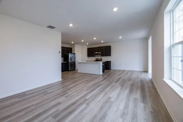 a view of a kitchen with wooden floor and a window