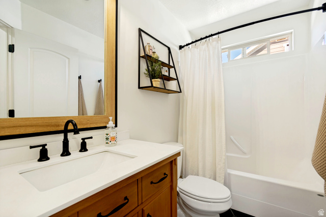 983 West 1550th Street South Springville, UT 84663 - Photo 30 of 43 Bathroom featuring a wood-finish vanity with a white countertop and integrated sink, a large mirror with wood and black framing, and a shower/tub combination with a white surround.