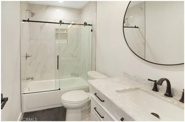 a bathroom with a granite countertop sink toilet and shower