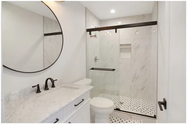 a bathroom with a sink toilet and a mirror