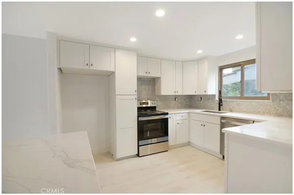 a kitchen with stainless steel appliances granite countertop a sink and a stove
