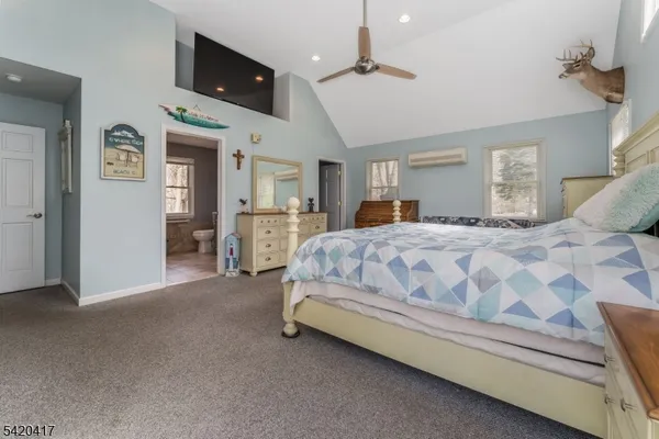 a spacious bedroom with a bed and a chandelier