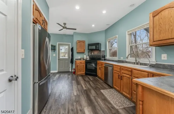 a large kitchen with stainless steel appliances granite countertop a lot of counter space and wooden floor
