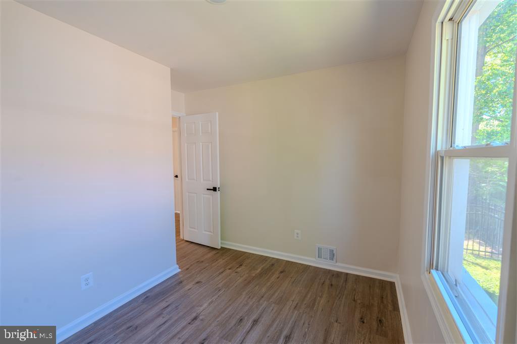 12324 Centerhill Street Silver Spring, MD 20902 - Photo 9 of 24 a view of an empty room with wooden floor and a window