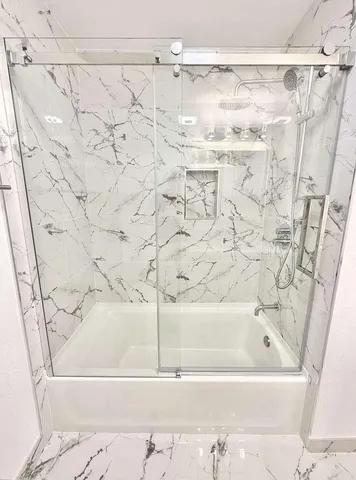 a bathroom with a bathtub and shower