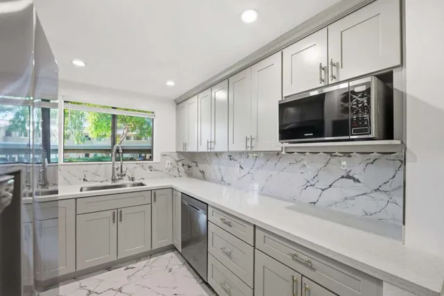 a kitchen with stainless steel appliances granite countertop a sink a stove and microwave