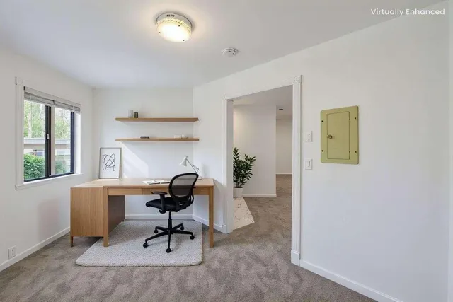 a view of a workspace with furniture and a window
