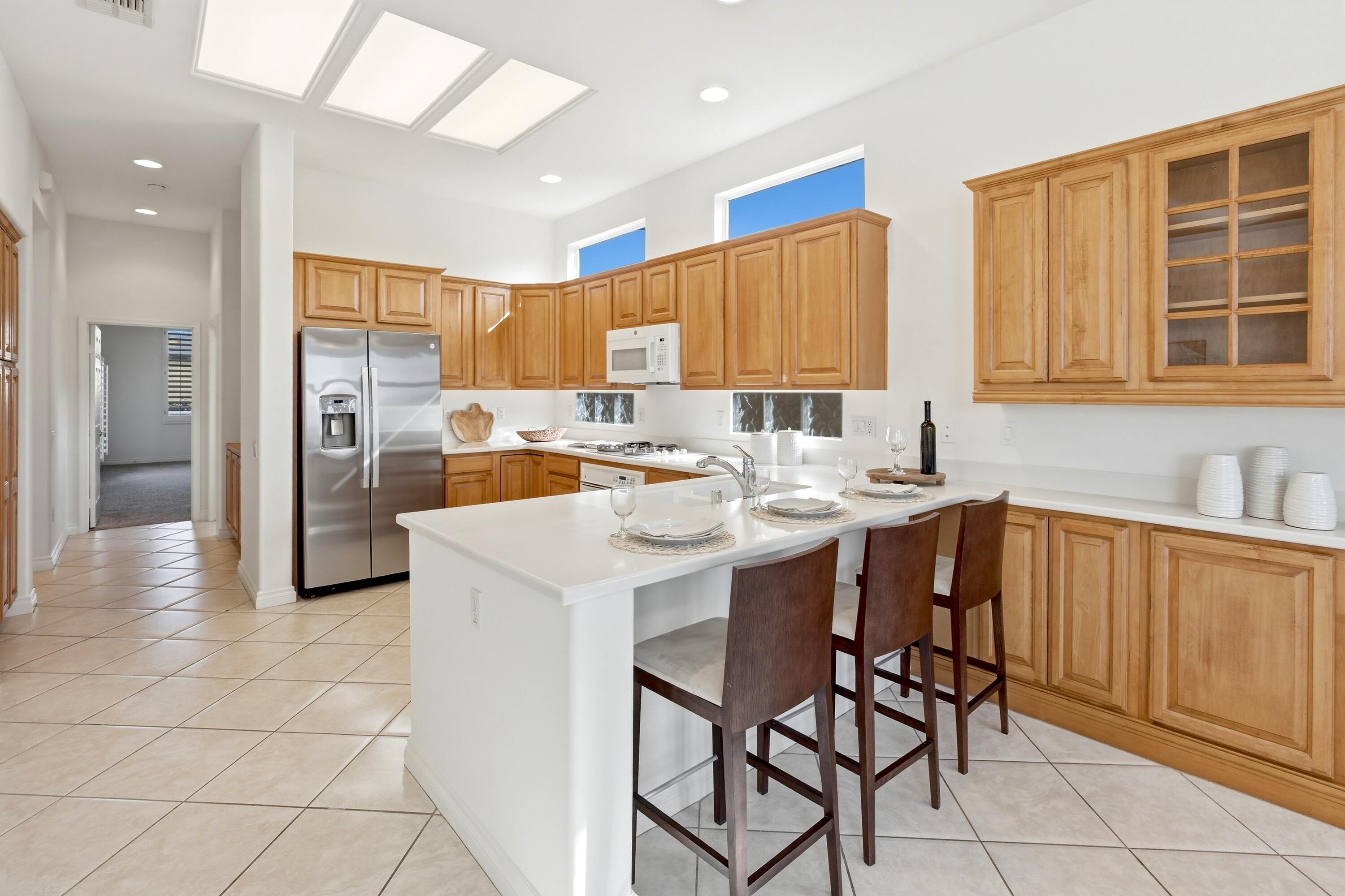 35440 Moorbrook Road Palm Desert, CA 92211 - Photo 15 of 32 a kitchen with stainless steel appliances kitchen island granite countertop a sink and cabinets