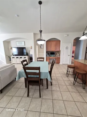 a living room with furniture a chandelier and a flat screen tv