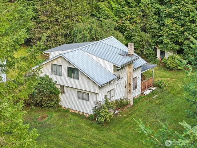 a aerial view of a house next to a big yard and large trees