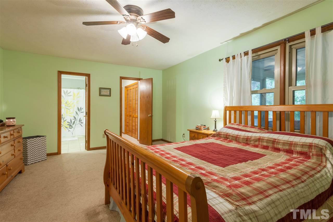 919 Grovemont Road Raleigh, NC 27603 - Photo 11 of 24 a bedroom with a bed and a chandelier