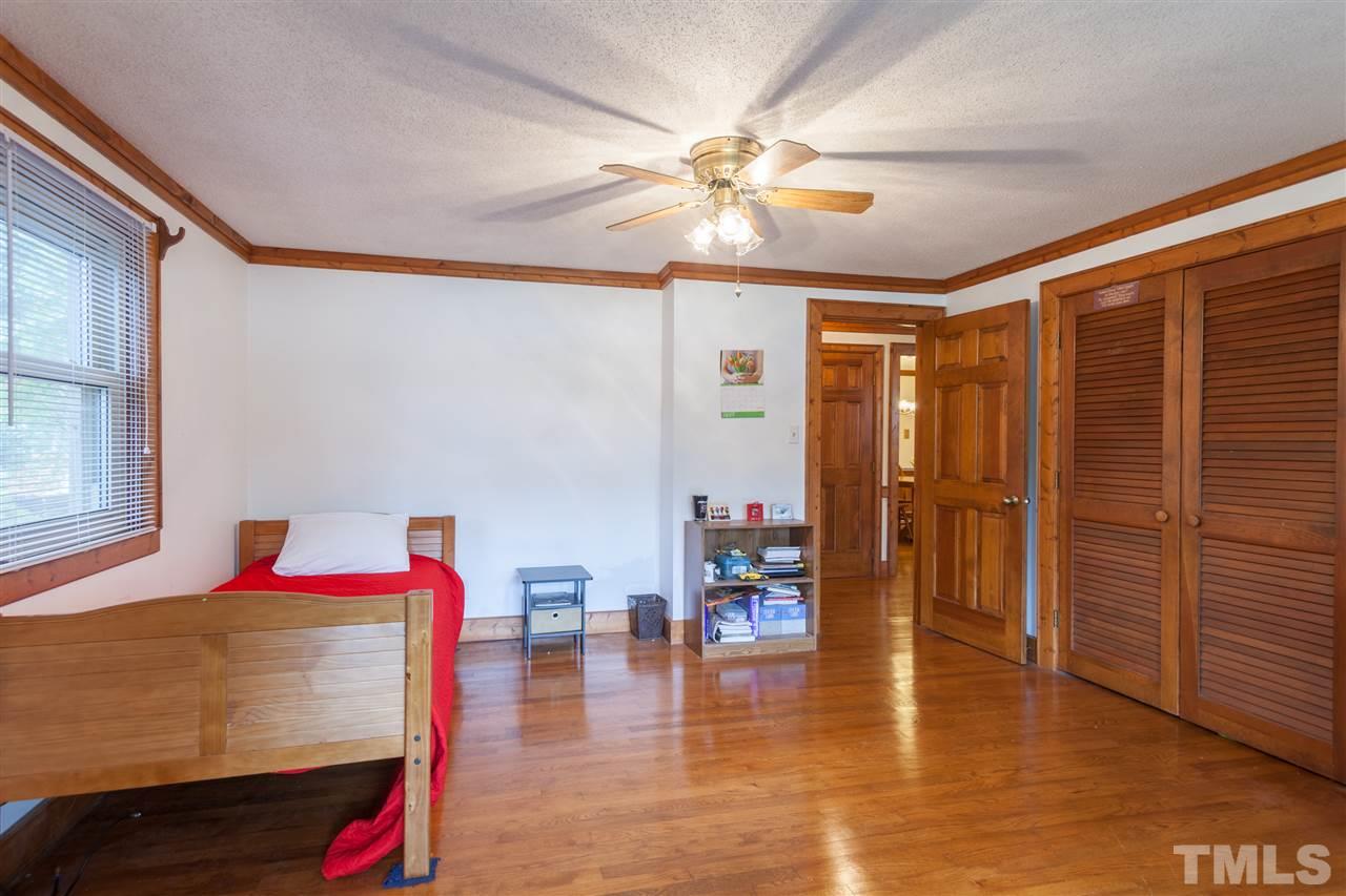 919 Grovemont Road Raleigh, NC 27603 - Photo 13 of 24 a bedroom with a bed and a chandelier