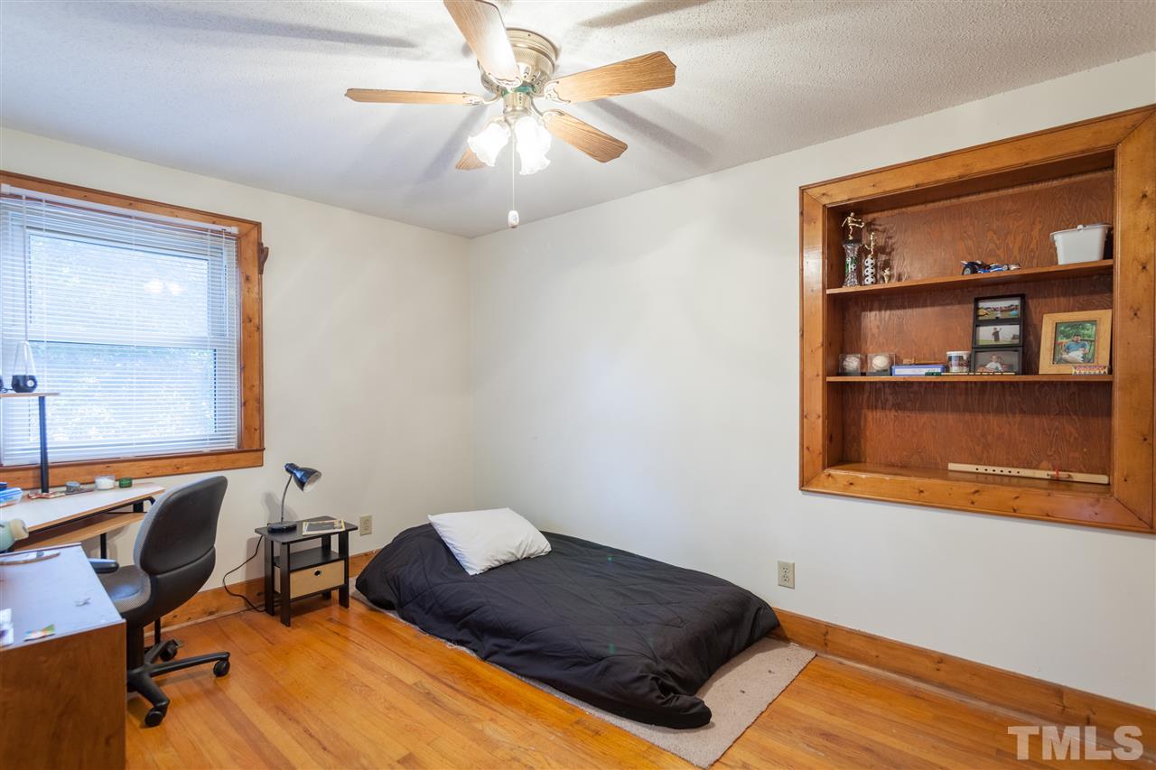 919 Grovemont Road Raleigh, NC 27603 - Photo 14 of 24 a bedroom with a bed and a bookshelf