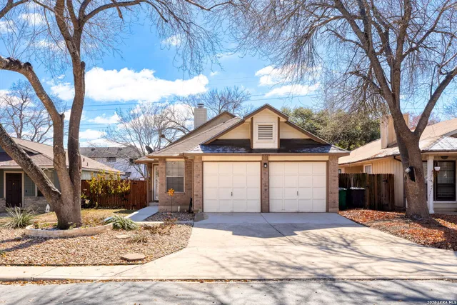 a white house that has a tree in front of it