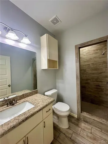 a bathroom with a granite countertop sink toilet and shower
